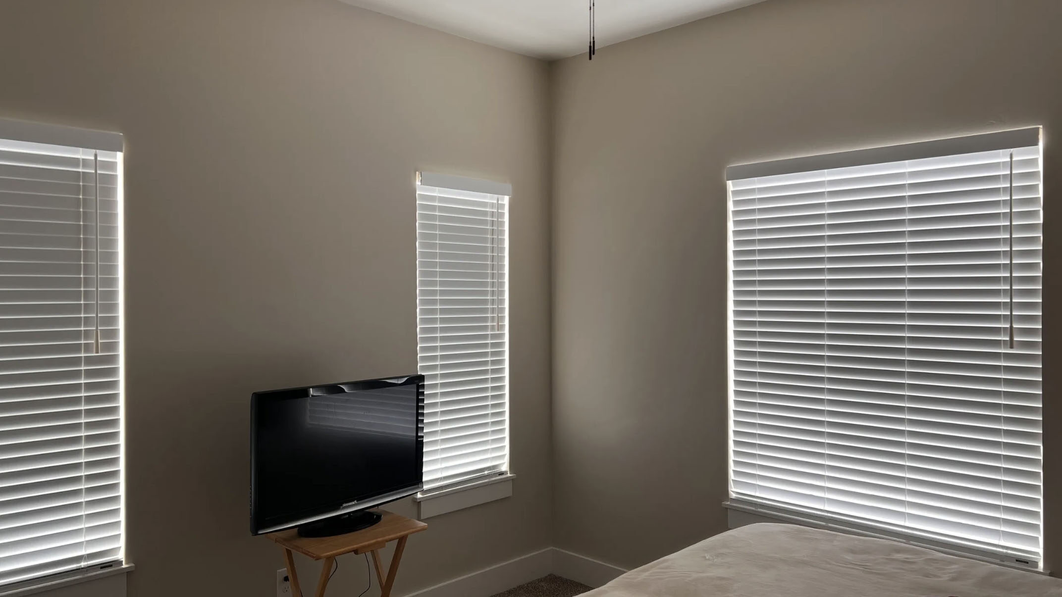 small room with 3 windows with blinds closed